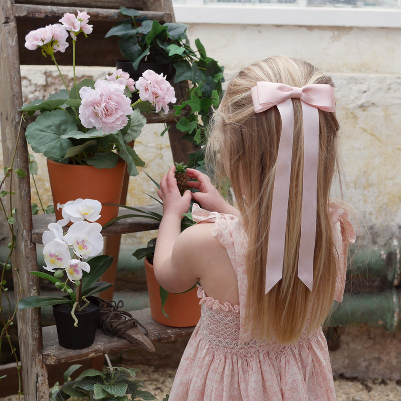 Little Love Fleur Satin Bow Barrette in Pink, Oversize satin hair bow, pale pink satin hair bow, silk satin hair bow uk, pink bow for little girll, flower girl bow satin, large silk bow in hair, pink satin bow on little girl with long hair,  pink satin bow barrette, hair bow in pink satin, little girl wearing pink bow,  pink hair accessory
