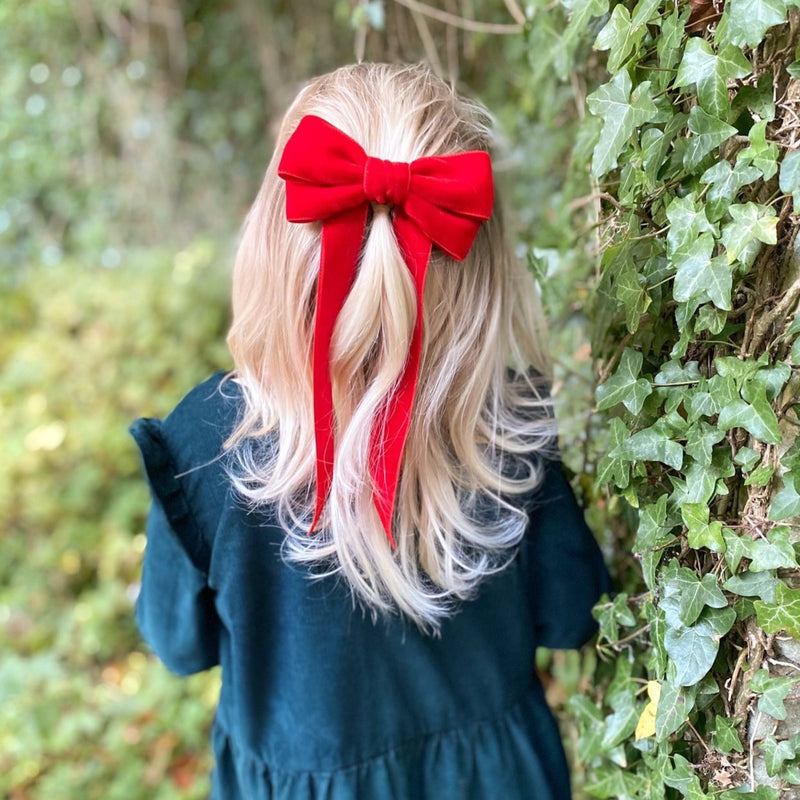 Little Love 'Ever After' velvet bow hair clip in true red, childrens red velvet hairbow for christmas worn on a little girl with long blonde hair, Red Velvet Hair Bow worn with Christmas Dress, red velvet hair bow, red velvet bow barrette, bow barrette, Christmas Hair bows, Girls Red Hair bow in velvet, little girls in red hair bows