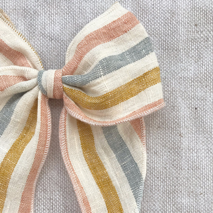  rainbow stripe linen bow hair clip for girls, rainbow cotton bow hair clips, muted rainbow hair bow, neutral rainbow bow hair clips, little love handmade hair bows, childrens hair accessorries uk, luxury kidswear uk, girls hair bows, mustard rainbow hair bow, linen hair bow, hair bows uk, stripe linen bow 