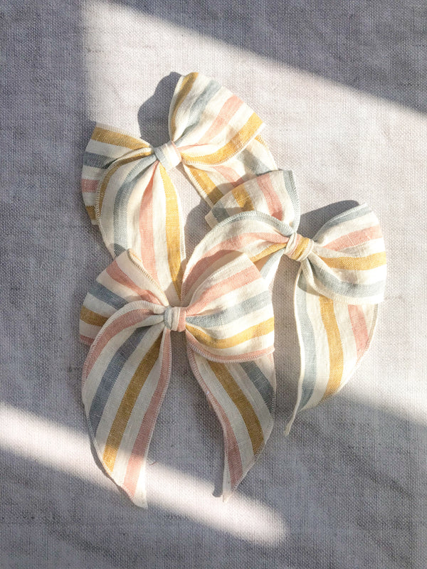  rainbow stripe linen bow hair clip for girls, rainbow cotton bow hair clips, muted rainbow hair bow, neutral rainbow bow hair clips, little love handmade hair bows, childrens hair accessorries uk, luxury kidswear uk, girls hair bows, mustard rainbow hair bow, linen hair bow, hair bows uk, stripe linen bow 